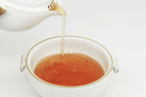 tea pours into white teacup